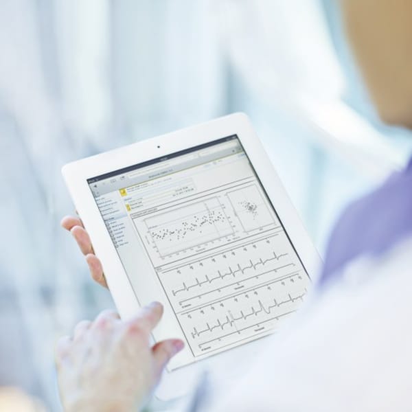 Ärztin prüft Home Monitoring Daten auf ihrem iPad.